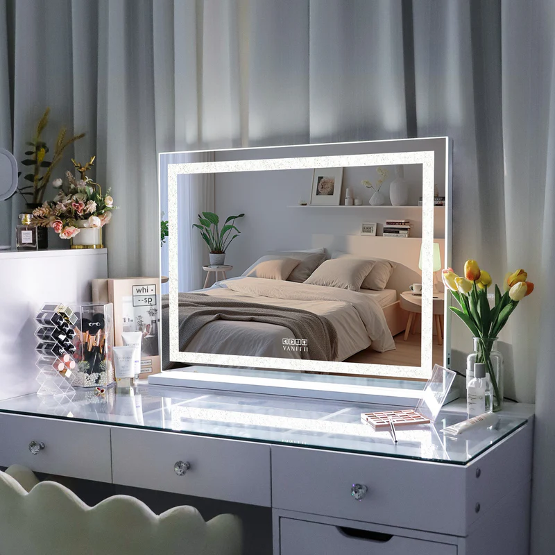 Dresser with a large vanity mirror featuring LED lighting, surrounded by decorative items.