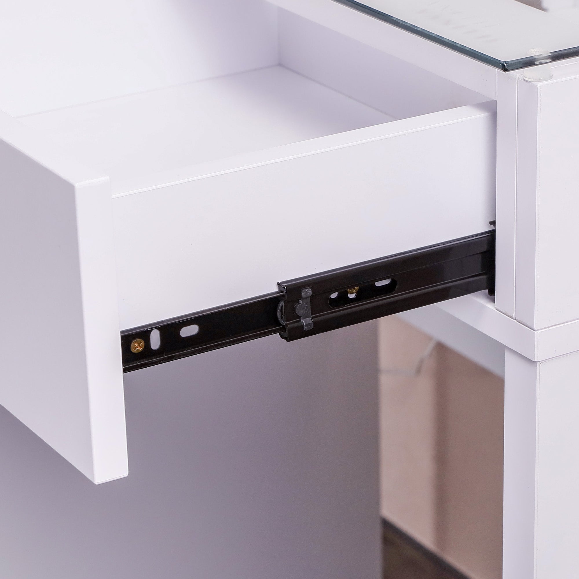 Close-up of a white vanity desk with an open drawer showing a black slide mechanism.
